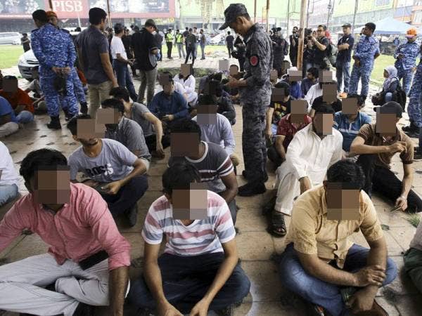 Anggota Jabatan Imigresen Malaysia memeriksa dokumen warga asing yang ditahan bagi menentukan dokumen dan pasport yang dimiliki mereka sama ada tulen atau sebaliknya pada Operasi Bersepadu di sekitar Pusat Komersil Nilai 3 hari ini. - Foto Bernama