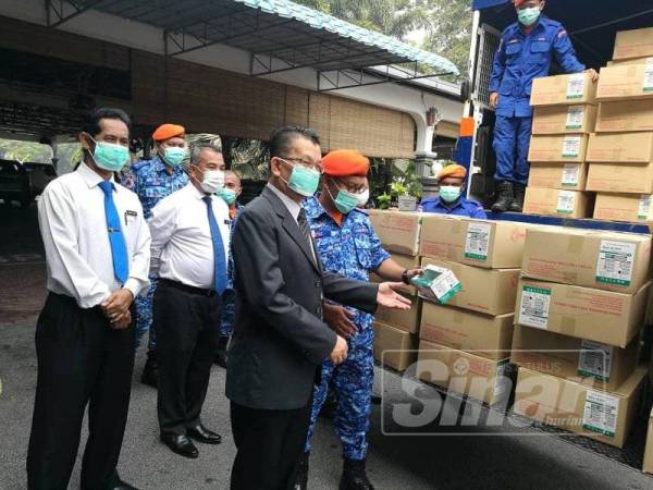 Mohammad Nek Ezar (kiri) melihat sumbangan topeng muka yang diserahkan oleh APM Negeri Sembilan pagi tadi. -Foto Sinar Harian