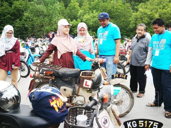 Nor Azrina (dua kiri) melihat salah sebuah motosikal klasik yang turut menyertai program semalam.