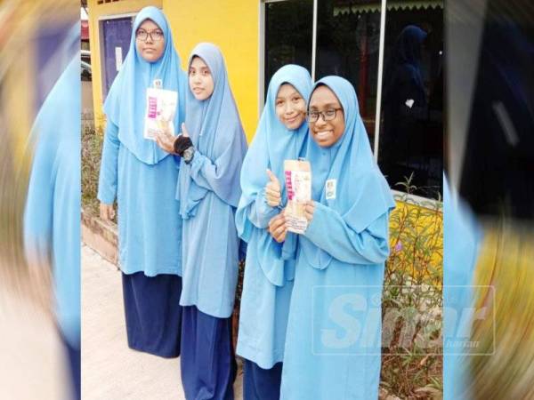 Nur Sakinah (kanan) menunjukkan produk makanan kucing mereka yang dijual dengan harga RM2 untuk 100 gram.