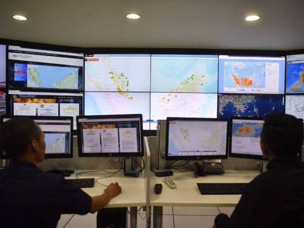 Petugas Agensi Pengurusan Bencana Negara Malaysia (NADMA) Nasrul Hadi Ishak (kiri) bersama Mohd Suhainizam Abdul Halim ketika meninjau keadaan kitaran angin mengenai cuaca jerebu yang melanda negara ketika ini di Markas Pasukan Mencari Dan Menyelamat Khas Malaysia (SMART), NADMA hari ini. - Foto Bernama