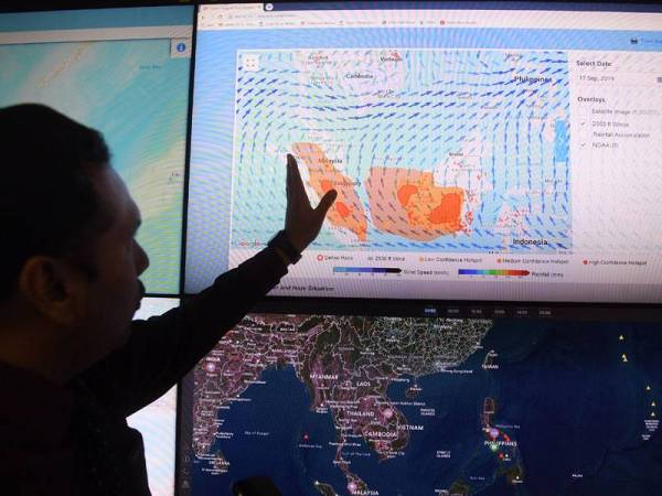 Pegawai Meteorologi Pusat Kawalan Bencana Negara, Mohamed Azan Abdul Halim menunjukkan kitaran angin dan Indeks Pencemaran Undara (IPU). - Foto Bernama