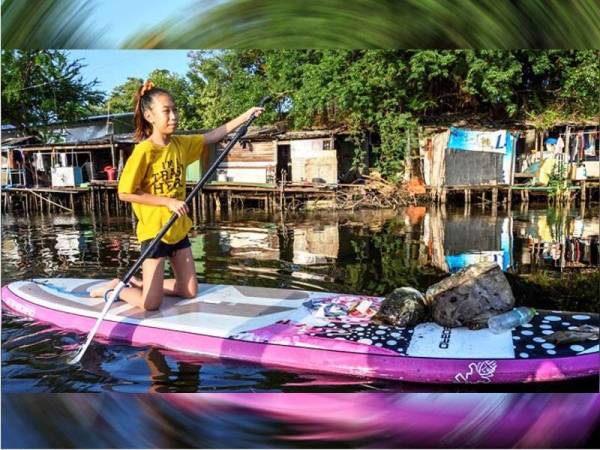 Lilly mengutip sampah sarap di sepanjang terusan Bangkok yang kotor. - Foto AFP