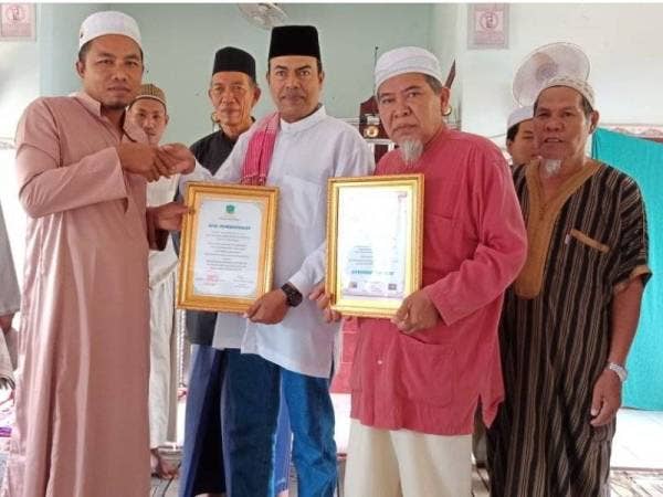 Mustapha (dua dari kiri) memegang sijil penghargaan diterima daripada Pengetua Sekolah Tahfiz, Ustaz Ramly Yusof. Turut hadir, Abd Manap (dua dari kanan).