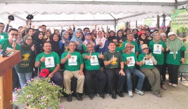Loy Sian (duduk, tiga dari kiri) bergambar bersama pensyarah dan penuntut UiTM pada Program Penanaman Pokok Nipah di Jeti Nelayan Kampung Sungai Kajang di sini hari ini.