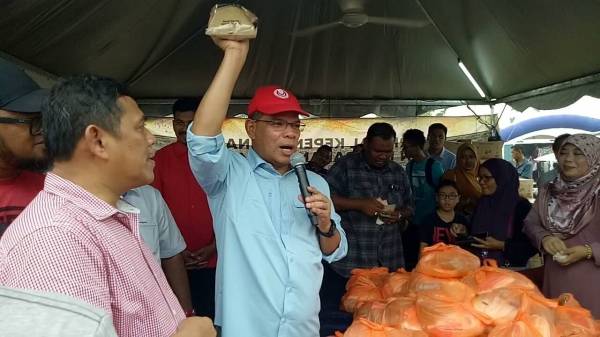 Saifuddin melelong gula perang yang dijual pada harga RM1 sebungkus di sebuah gerai yang mengambil bahagian di fiesta berkenaan, di sini hari ini.