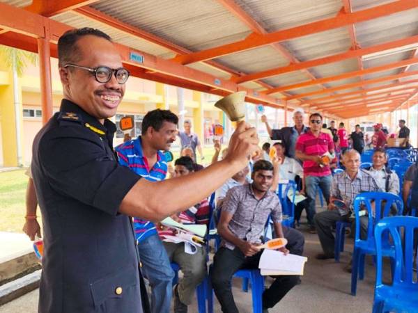 Hanif Yusabra (kiri) membunyikan loceng melelong Toyota Estima di acara lelongan kenderaan JPJ Kelantan hari ini.