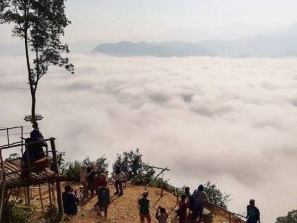 Pelancong datang untuk menikmati keindahan hamparan awan dari puncak gunung pada waktu pagi. - Foto Kompas
