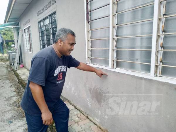 Abdul menunjukkan paras air yang naik sewaktu banjir pada lima tahun lalu.