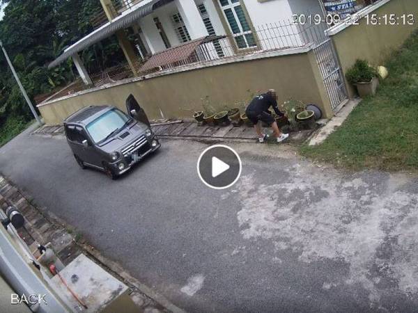 Rakaman CCTV menunjukkan seorang lelaki sedang mengambil pasu di tepi sebuah rumah.