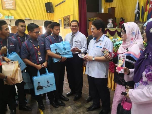 Mohamad Rafie(tiga dari kanan) beramah mesra dengan pelajar selepas menyampaikan sumbangan kit peperiksaan. 