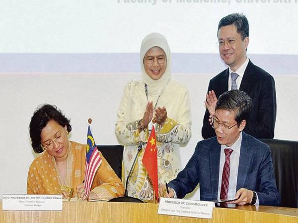 DEKAN Fakulti Perubatan Universiti Malaya, Datuk Dr Adeeba Kamarulzaman bersama Dr Guoqiang Chen ketika menandatangani MoU antara Universiti Malaya dengan Sekolah Perubatan Universiti Jiao Tong Shanghai dalam bidang pembedahan pemindahan hati kanak-kanak. 