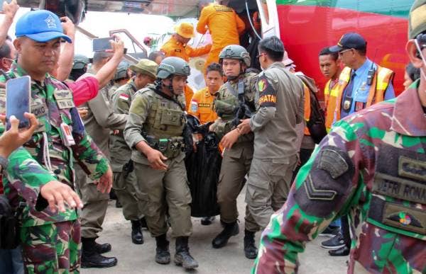 Anggota penyelamat membawa mayat mangsa yang ditemukan di lokasi nahas tiba di Lapangan Terbang Mozes Kilangin di Timika, wilayah Papua hari ini. - Foto: AFP