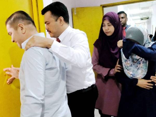 Mohd Zul Azmi dan Mazlyda diiringi pegawai SPRM ke Mahkamah Sesyen Johor Bahru hari ini.