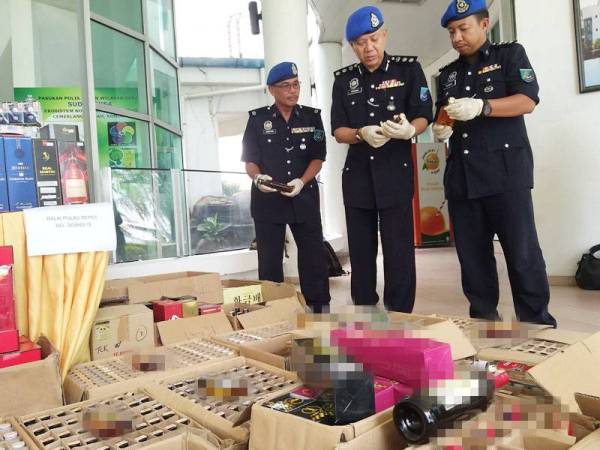 Rosman (tengah) bersama pegawainya memeriksa botol minuman keras yang dirampas.