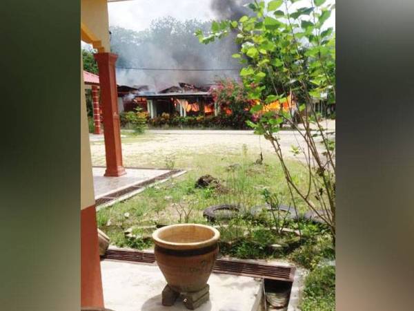 Rumah yang sedang dijilat api dapat dilihat dengan jelas dari kediaman jiran.