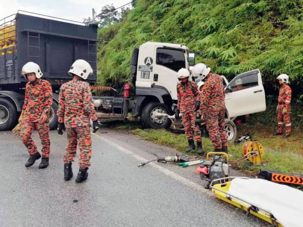 Anggota bomba mengeluarkan mangsa yang tersepit dalam kenderaan.
