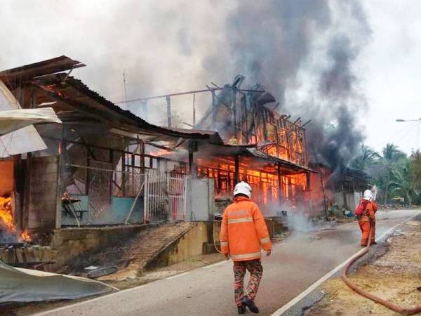 Pasukan bomba mengawal api bagi mengelakkan kebakaran terus merebak ke rumah lain. - Foto Bomba Johor