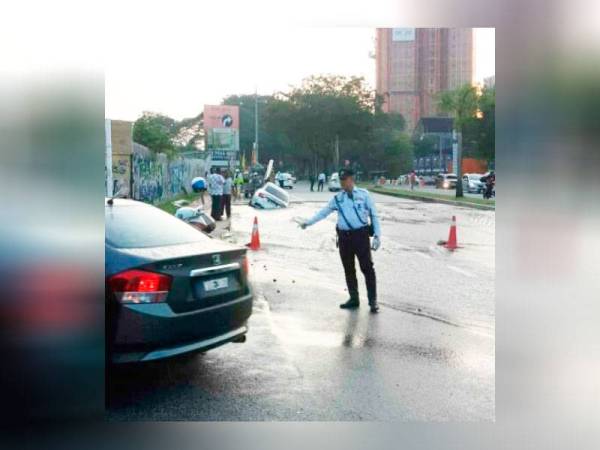 Anggota trafik mengawal laluan di kawasan berkenaan susulan kejadian paip pecah itu. -Foto Ihsan IPD Petaling Jaya