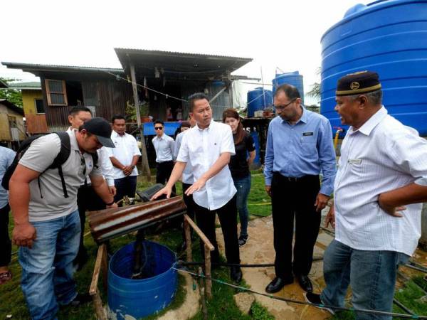 Menteri Pembangunan Infrastruktur Sabah Datuk Peter Anthony (tiga, kanan) melihat keadaan perigi yang dijadikan sebagai sumber air penduduk sambil diperhatikan Ketua Kampung Pulau Berhala, Junior Jikirin (kanan) sewaktu mengadakan lawatan dan meninjau kemudahan asas yang terdapat di pulau itu hari ini. Turut hadir, Pengarah Jabatan Air Sabah Ir Amarjit Singh (dua, kanan). - Foto Bernama
