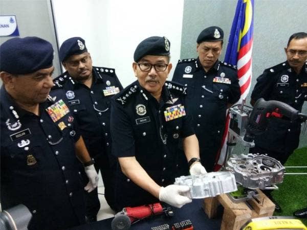 Mazlan menunjukkan barangan yang dirampas polis.