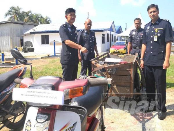 Chee Khoon (kiri) bersama pegawainya menunjukkan barangan dirampas pada sidang akhbar di IPD Sabak Bernam di sini hari ini.