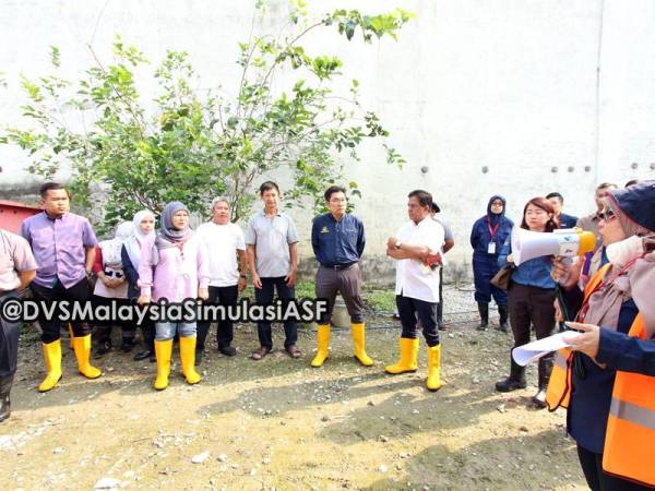 Tze Tzhin (enam dari kiri) mendengar penerangan ketika sesi latihan simulasi semalam.