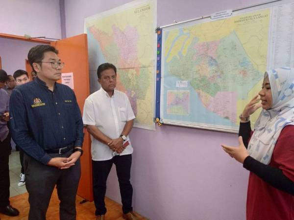 Tze Tzin (kiri) mendengar penerangan daripada Ketua Seksyen Kawalan Penyakit DVS Selangor, Dr Norhamizah Abdul Hamid (kanan).