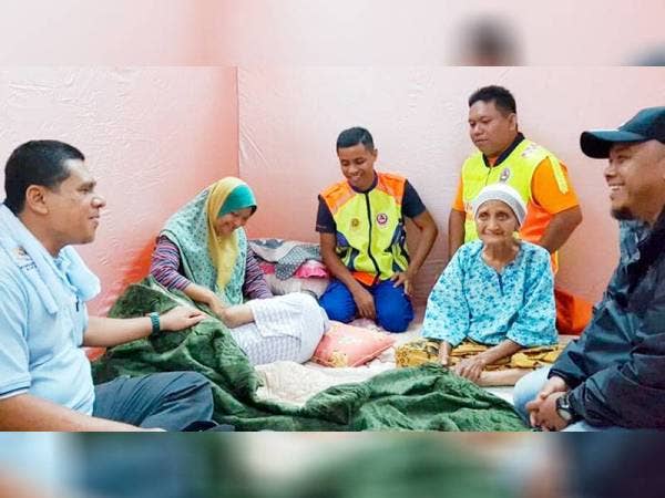 Anggota APM melawat mangsa banjir di pusat pemindahan di Baling. - Foto APM
