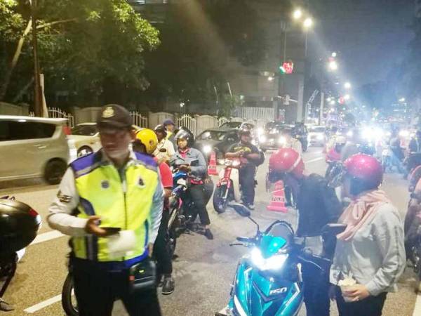 Anggota polis memeriksa penunggang motosikal pada Op Bersepadu di Jalan Raja Laut, Kuala Lumpur di sini awal pagi tadi.