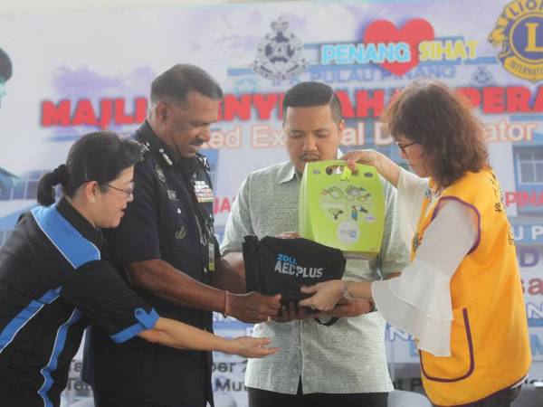 Afif (dua dari kanan) menyampaikan peranti AED kepada Narenasagaran di sini hari ini.