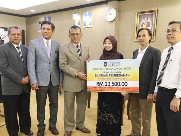 Syarmeliah (tiga dari kanan) menerima bantuan pembiayaan penuh pembedahan skoliosis berjumlah RM 23,500 dari Dana Wakaf dan Tabung Kebajikan dan Perlindungan Mahasiswa (TKPM) UniSZA yang disampaikan Dr Hassan Basri (tiga dari kiri) di pejabat Naib Canselor hari ini.