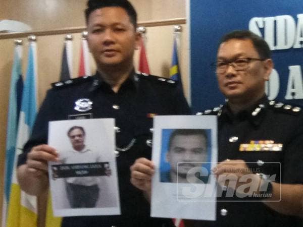 Noor Azmi (kanan) bersama pegawai poliss menunjukkan gambar dua beranak yang dipercayai boleh membantu siasatan kes penipuan visa pekerjaan.