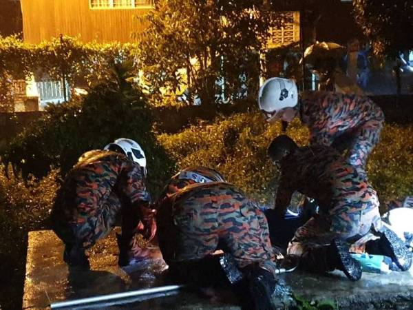 Anggota bomba membantu mengeluarkan mayat mangsa yang terjatuh ke dalam tangki kumbahan malam tadi.