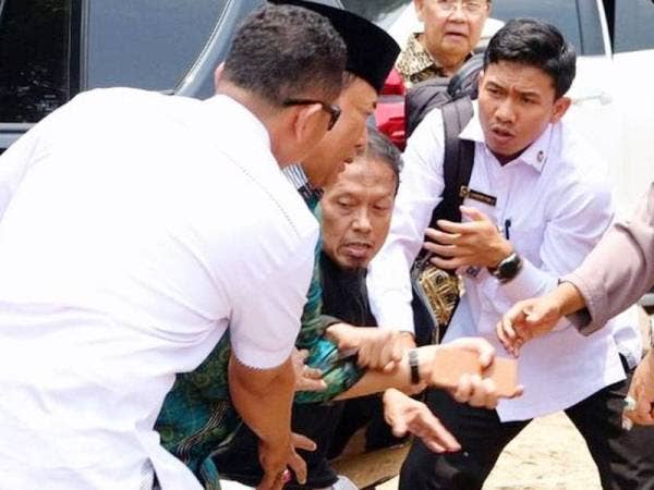 Menteri Keselamatan Indonesia, Wiranto (dua dari kiri) cuba mengelak tikaman seorang lelaki yang meluru ke arahnya.