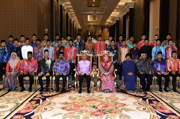 Al-Sultan Abdullah dan Tunku Azizah berkenan bergambar bersama skuad hoki negara ketika berangkat tiba ke Majlis Santapan Hi-Tea Negara di Istana Negara semalam. - Foto Bernama