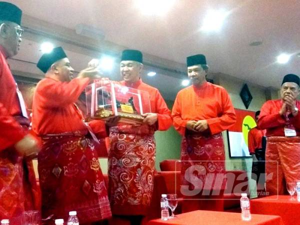 Ahmad Zahid menerima cenderahati daripada Saarani selepas merasmikan Konvensyen UMNO Perak di Bangunan UMNO Negeri Perak di sini hari ini.