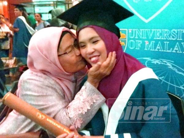 Dayangku Aishah (kanan) dicium ibunya, Dayang Hajijah Awang Dewa, 66 selepas menerima anugerah diploma Pascasiswazah Pendidikan pada Istiadat Konvokesyen UM ke-59 hari ini