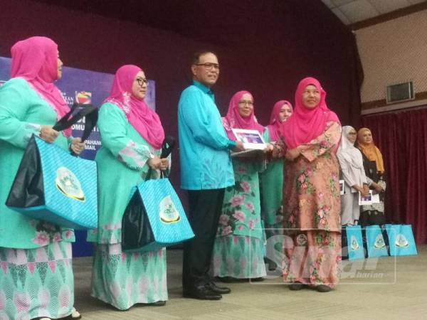 Wan Rosdy menyampaikan sumbangan kepada wakil PDK negeri ini.