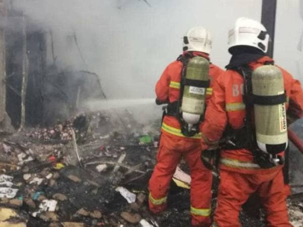 Anggota bomba bertungkus-lumus memadam kebakaran kilang terbabit sebelum api berjaya dikawal bagaimanapun 80 peratus struktur bangunan berkenaan musnah terbakar. Foto: Ihsan bomba