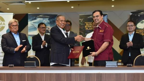 PRESIDEN Pekeme, Datuk Zainuddin Abd Rahman (kiri) bersalaman dengan Dr Azlan selepas menandatangani MOA antara Pekema dan UTM di Cyberjaya, baru-baru ini.