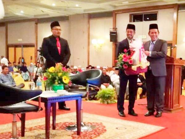Aminuddin (kanan) menerima cenderahati disampaikan Pengarah Jabatan Hal Ehwal Agama Islam Negeri Sembilan (JHEAINS), Mohd Zaidi Ramli.