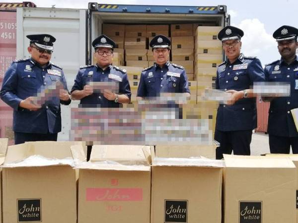 Paddy (dua dari kiri) menunjukkan antara rampasan rokok yang dirampas dalam operasi di Pelabuhan Utara, Pelabuhan Klang Jumaat lalu.