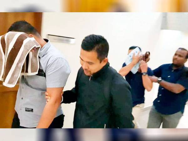 Muhammad Rayyan John (depan) dan Stenley Blasius diiringi pegawai SPRM keluar dari kamar mahkamah.