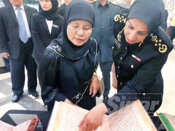 Latheefa (kanan) meneliti manuskrip lama bersama Ketua Hakim Negara, Tengku Maimun (kiri).