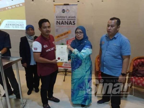 Ruhaida (dua dari kanan) menyampaikan sijil kepada wakil peserta kursus Asas Tanaman Nanas.