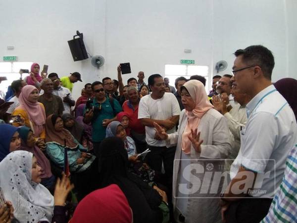 Zuraida sedang menerangkan tentang jalan penyelesaian yang akan diambil terhadap masalah penduduk terlibat.