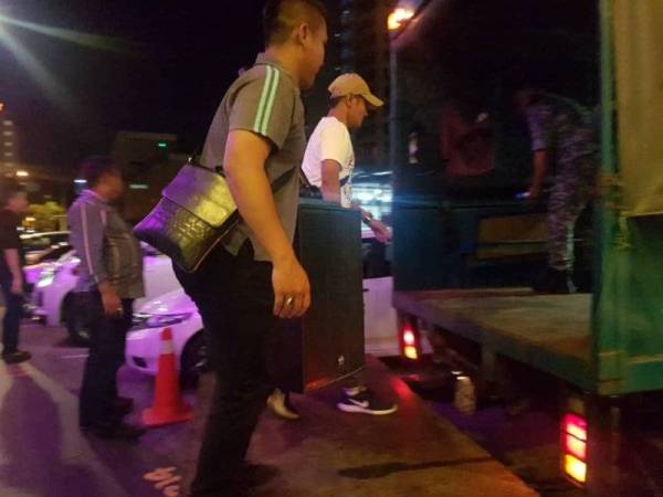 Anggota penguatkuasa MPK sedang menyita barangan berupa emplifier dan sistem pembesar suara dari premis pusat hiburan tanpa lesen.