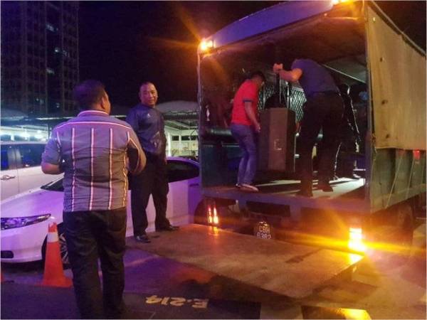 Anggota penguatkuasa MPK sedang menyita barangan berupa emplifier dan sistem pembesar suara dari premis pusat hiburan tanpa lesen.