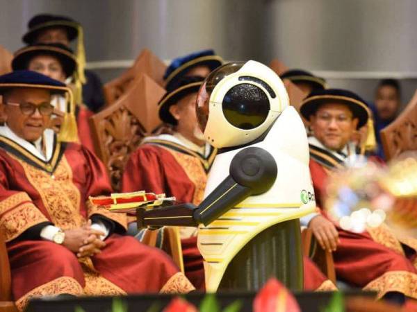 Robot Naseem menyerahkan skrol kepada Naib Canselor UniSZA, Prof Datuk Dr Hassan Basri Awang Mat Dahan sebelum meneruskan istiadat seterusnya. Foto: UniSZA.